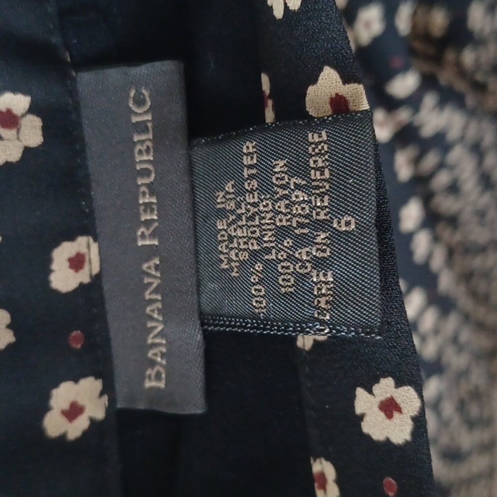 A size 6 black circle skirt. It has cream flowers on the skirt with red centers.